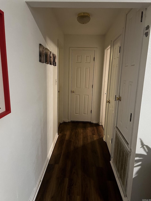 hallway with dark hardwood / wood-style flooring