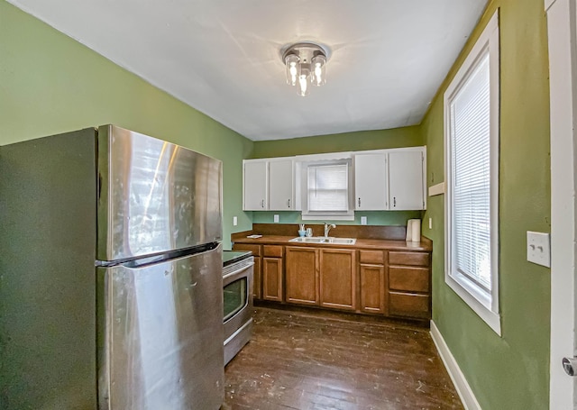 kitchen featuring stainless steel appliances, white cabinetry, dark hardwood / wood-style floors, and sink