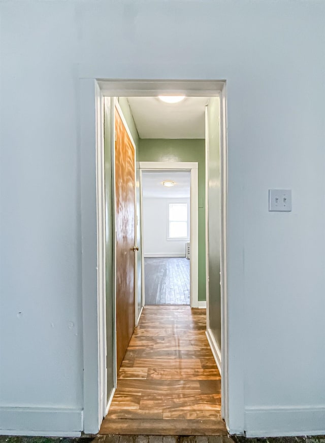 hallway with hardwood / wood-style flooring