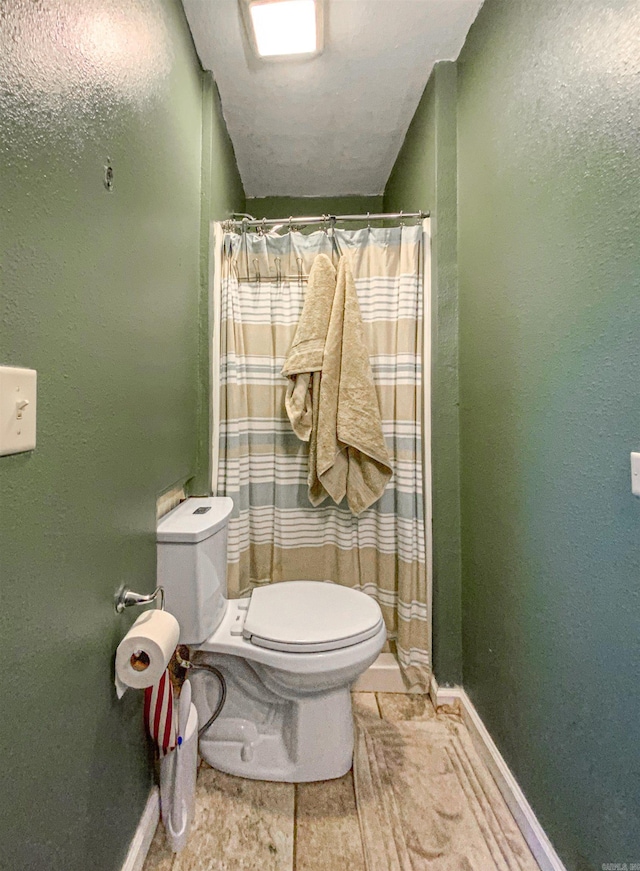 bathroom with curtained shower and toilet