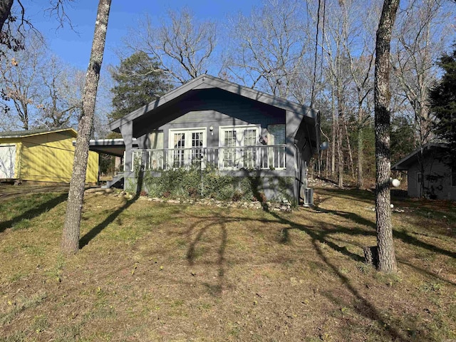 view of front facade featuring central AC unit and a front yard