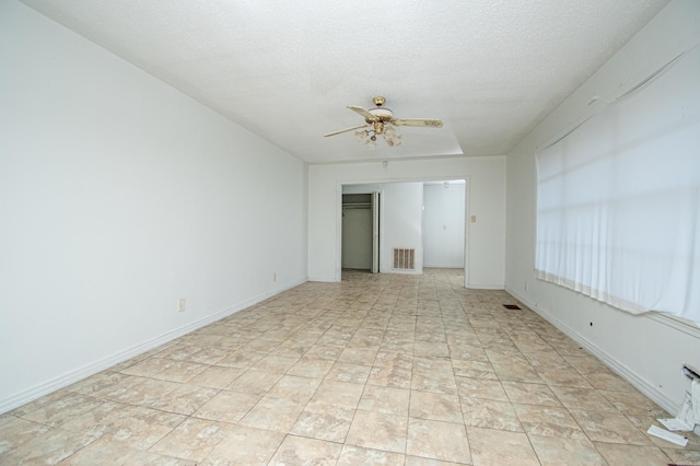 unfurnished room featuring ceiling fan and a textured ceiling