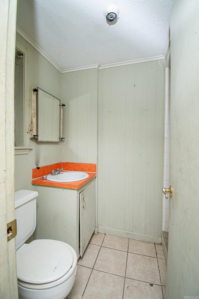 bathroom featuring ornamental molding, vanity, a textured ceiling, tile patterned flooring, and toilet