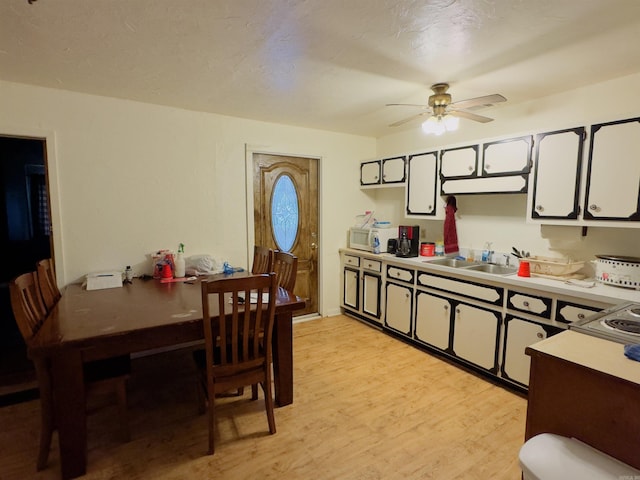 kitchen featuring white cabinetry, ceiling fan, sink, and light hardwood / wood-style flooring