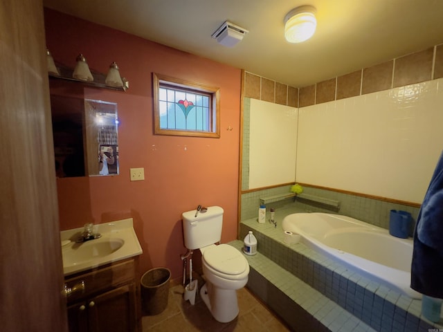 bathroom featuring vanity, tile patterned flooring, a relaxing tiled tub, and toilet