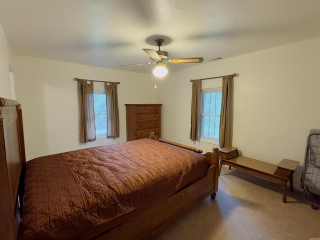 carpeted bedroom with ceiling fan and multiple windows