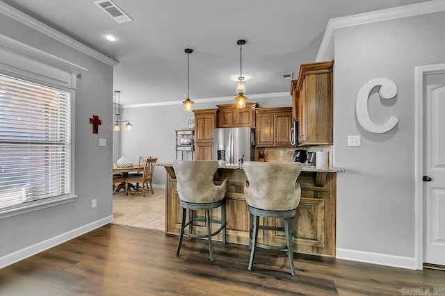 kitchen with a breakfast bar, light stone countertops, stainless steel appliances, and dark hardwood / wood-style floors