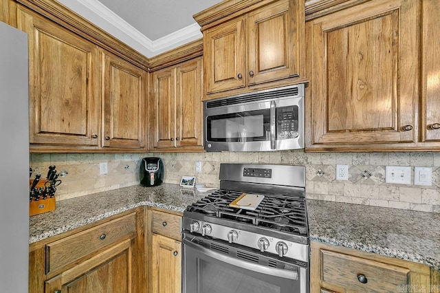 kitchen featuring appliances with stainless steel finishes, backsplash, ornamental molding, and dark stone countertops