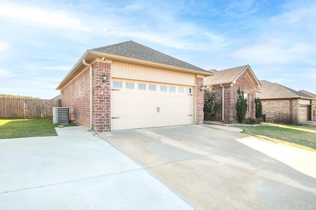 view of front of house featuring a front yard, a garage, and central AC unit