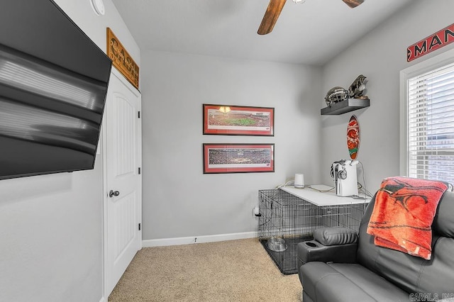 living area with carpet floors and ceiling fan