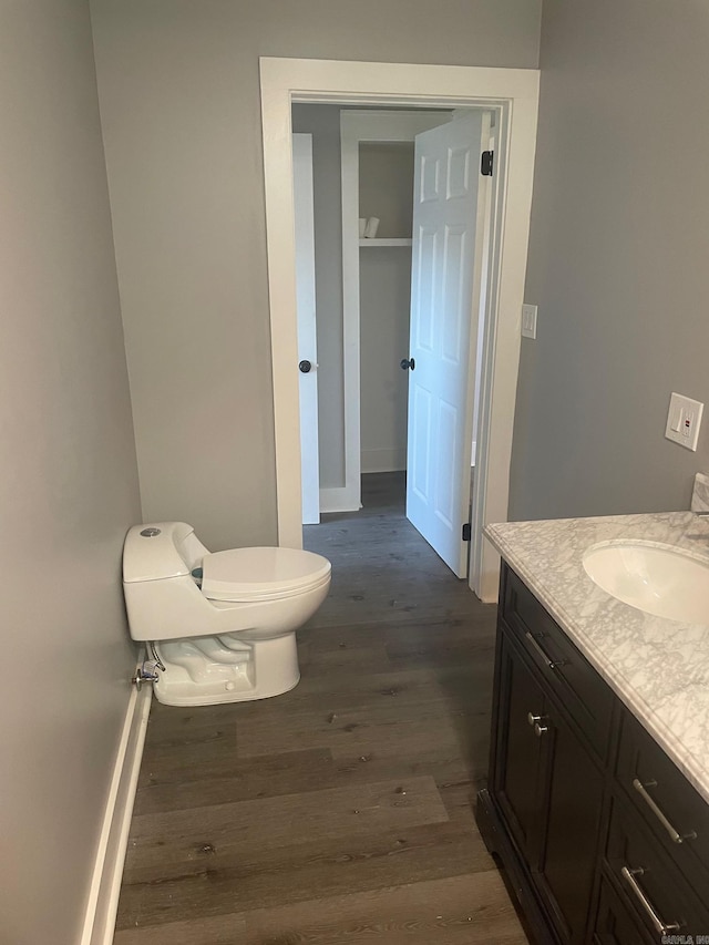 bathroom with vanity, wood-type flooring, and toilet