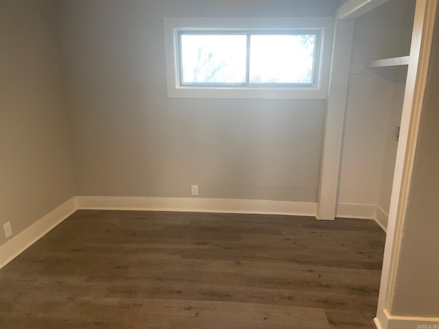 unfurnished room with dark wood-type flooring