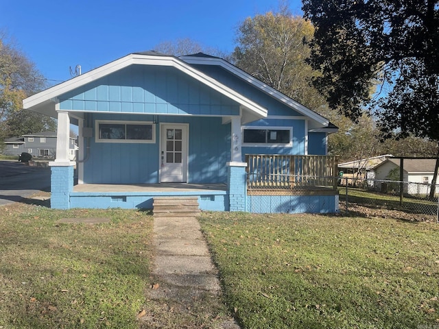 bungalow-style home featuring covered porch and a front lawn