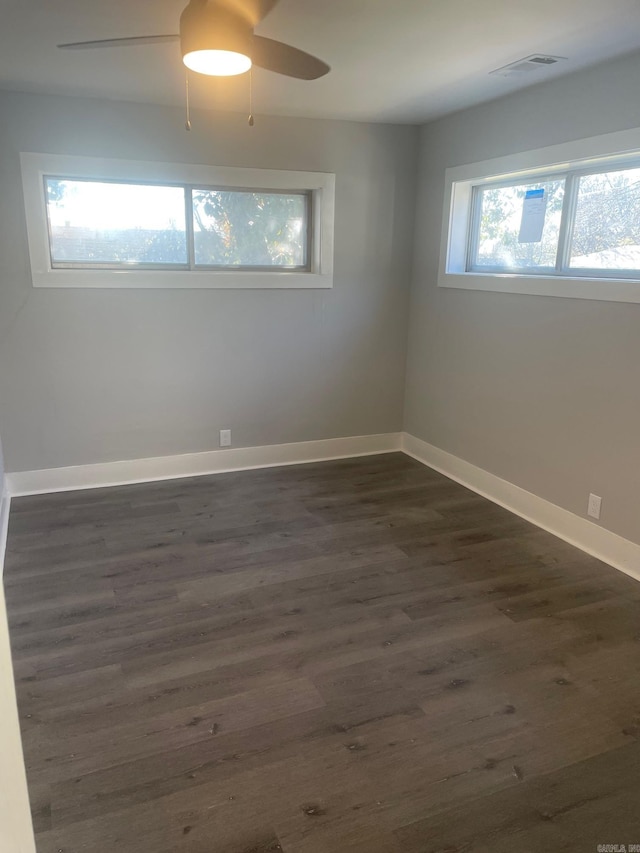 spare room with ceiling fan, plenty of natural light, and dark hardwood / wood-style floors