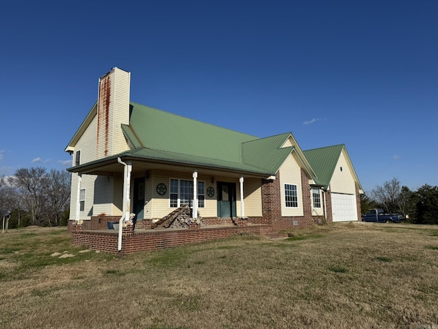 exterior space with covered porch, a yard, and a garage