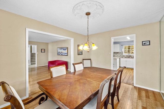 dining room with light hardwood / wood-style flooring, a chandelier, and sink