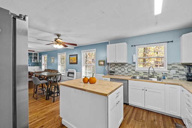 kitchen featuring white cabinetry, dishwasher, sink, and wood counters