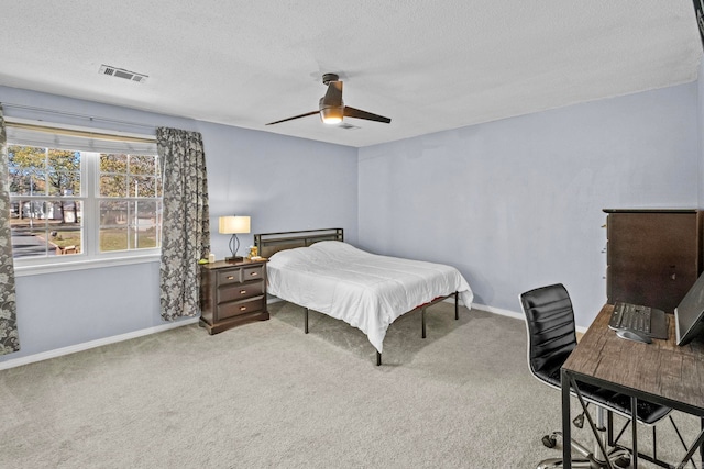 carpeted bedroom with ceiling fan and a textured ceiling