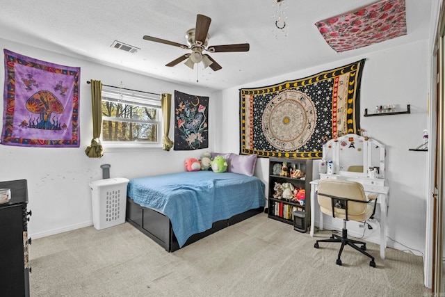 bedroom featuring a textured ceiling, light colored carpet, and ceiling fan