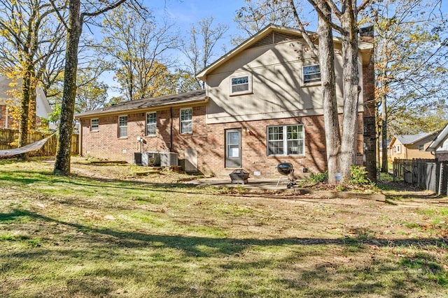 rear view of property with a yard, cooling unit, and a patio