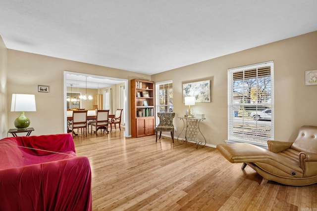 sitting room with hardwood / wood-style floors, a textured ceiling, and an inviting chandelier