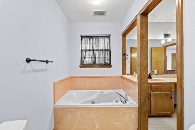 bathroom with vanity, toilet, and a bathing tub