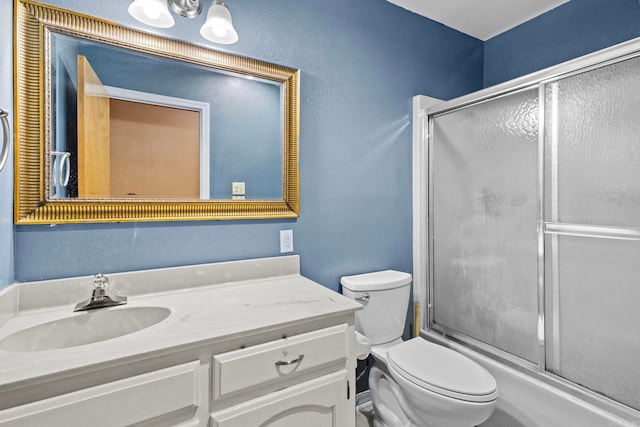 full bathroom with vanity, toilet, and bath / shower combo with glass door