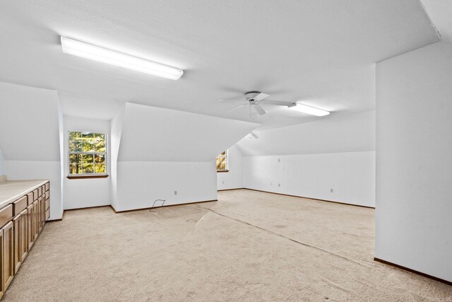 bonus room with light colored carpet, vaulted ceiling, and ceiling fan