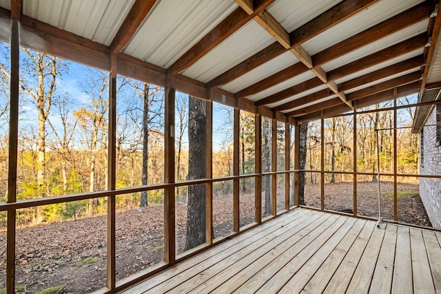 unfurnished sunroom featuring beam ceiling