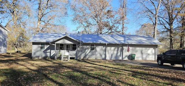 rear view of property featuring a lawn and a garage