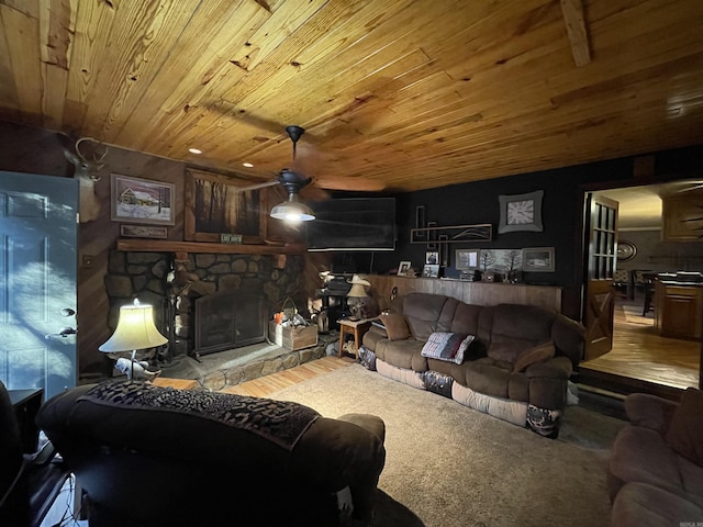 living room with hardwood / wood-style flooring, a stone fireplace, and wooden ceiling