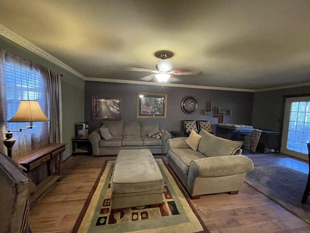 living room with wood-type flooring, ceiling fan, and crown molding
