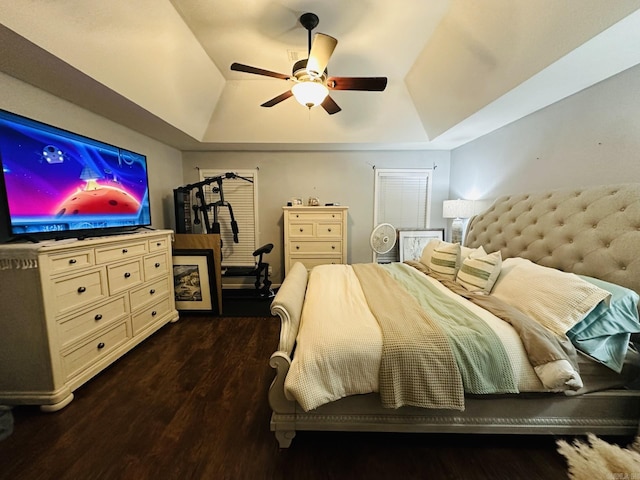 bedroom featuring a raised ceiling, ceiling fan, and dark hardwood / wood-style flooring