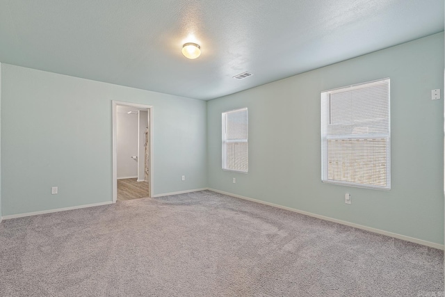 carpeted spare room featuring a textured ceiling