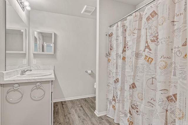 bathroom with a shower with curtain, hardwood / wood-style floors, and vanity