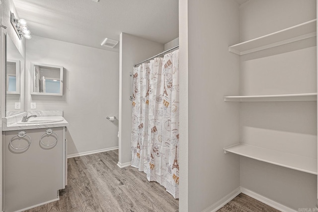 bathroom with vanity, a textured ceiling, and hardwood / wood-style flooring