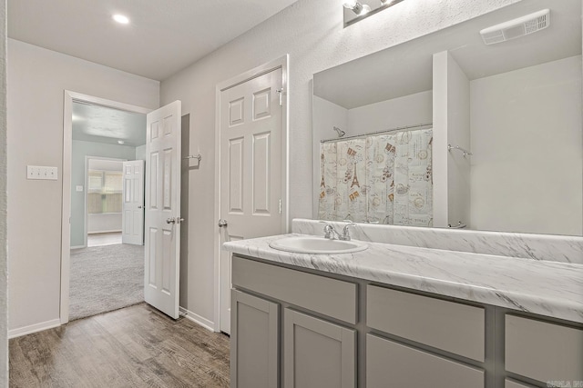 bathroom featuring vanity, wood-type flooring, and walk in shower