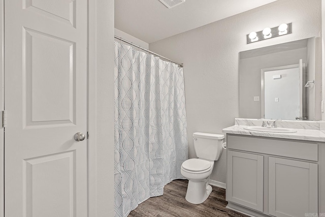 bathroom with hardwood / wood-style floors, vanity, and toilet