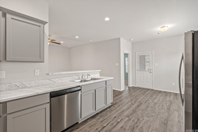 kitchen with gray cabinets, sink, stainless steel appliances, and light hardwood / wood-style flooring