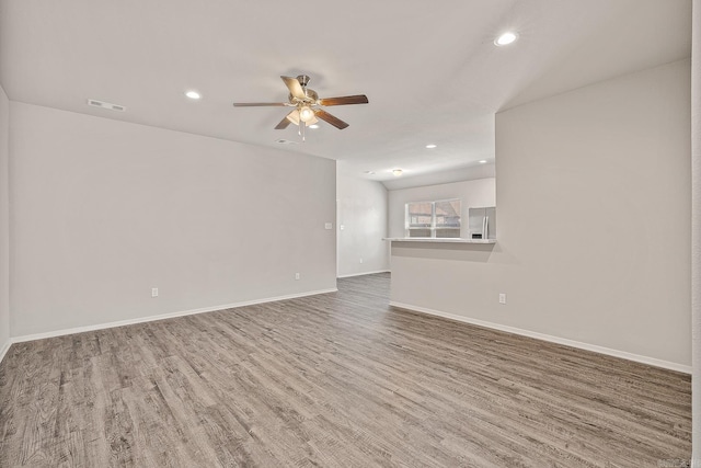 unfurnished living room featuring ceiling fan and hardwood / wood-style floors