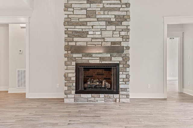 details featuring hardwood / wood-style flooring and a stone fireplace