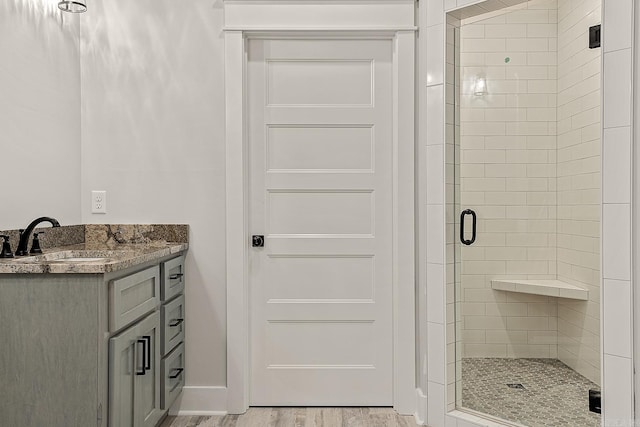 bathroom with vanity, an enclosed shower, and hardwood / wood-style flooring