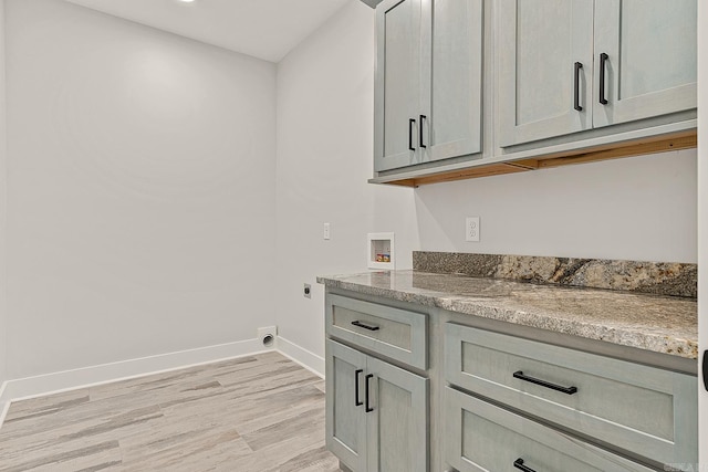 laundry room featuring washer hookup, electric dryer hookup, cabinets, and light hardwood / wood-style flooring