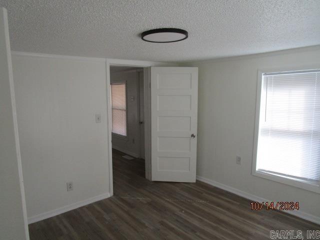 empty room featuring dark wood-type flooring and a textured ceiling