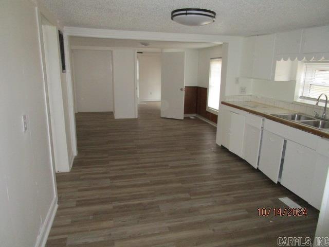 kitchen featuring white cabinets, dark hardwood / wood-style floors, sink, and a textured ceiling