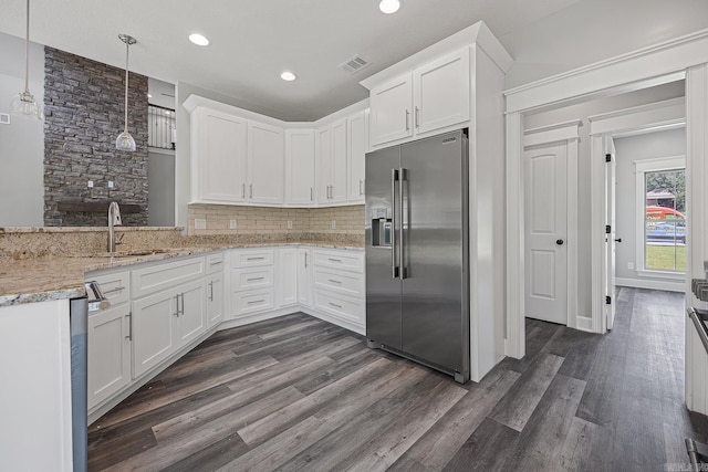 kitchen featuring white cabinets, appliances with stainless steel finishes, pendant lighting, and sink