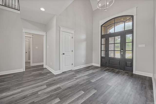 foyer entrance with dark hardwood / wood-style flooring, an inviting chandelier, and high vaulted ceiling