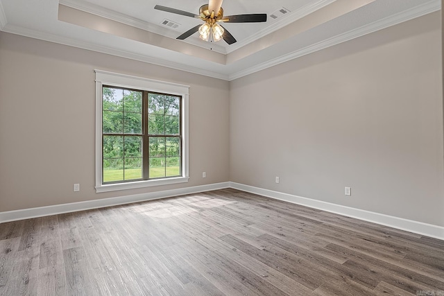 spare room featuring hardwood / wood-style flooring, a raised ceiling, ceiling fan, and ornamental molding