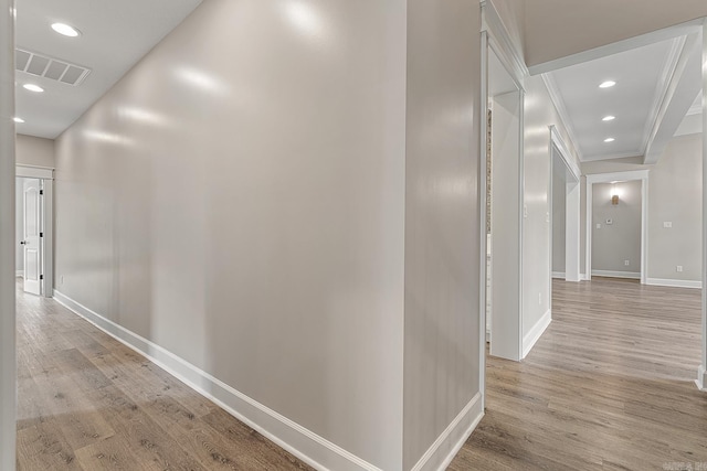 corridor featuring light hardwood / wood-style flooring and crown molding