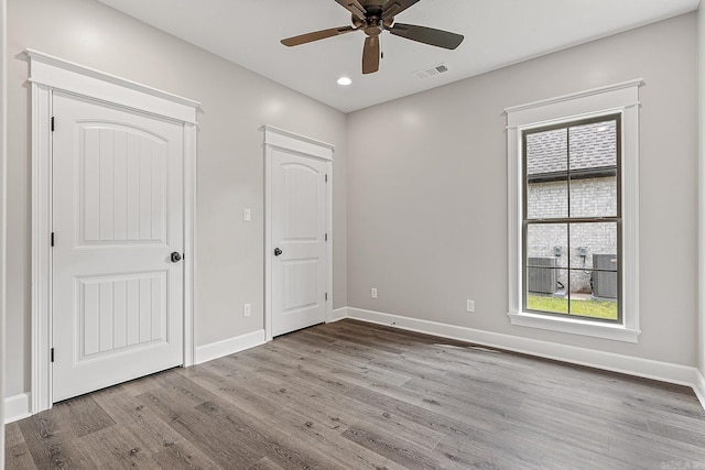 unfurnished bedroom with ceiling fan and light wood-type flooring